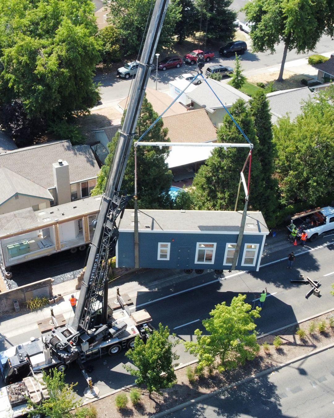 Modular home being delivered and installed by crane